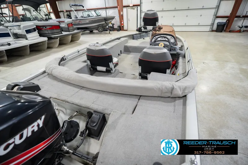 Slide: The Image of 2007 Tracker Tournament V-18 boat interior in showroom with Mercury engine. - 14