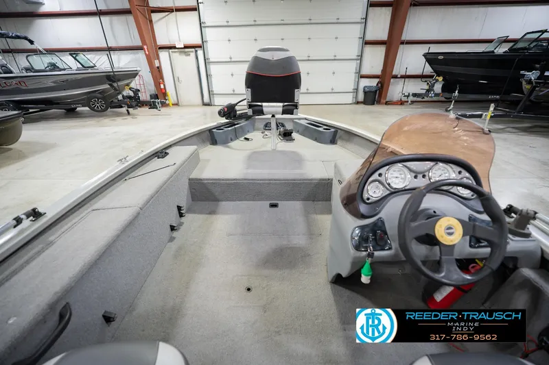 Slide: The Image of 2007 Tracker Tournament V-18 boat interior with steering wheel and dashboard in a showroom. - 17