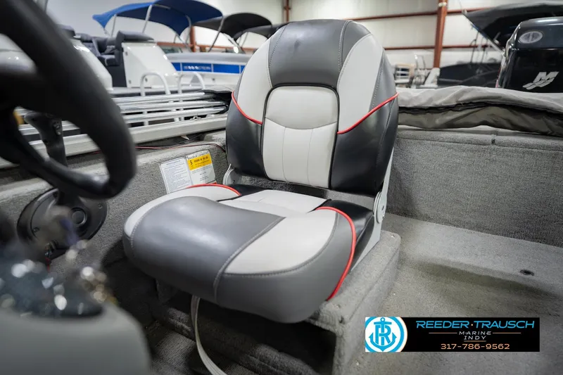 Slide: The Image of 2007 Tracker Tournament V-18 boat seat with black, white, and red accents in showroom. - 36