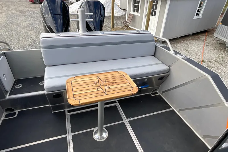 Slide: The Image of 2025 Life Proof 31 GT Coupe boat interior with gray seating and wooden table. - 28
