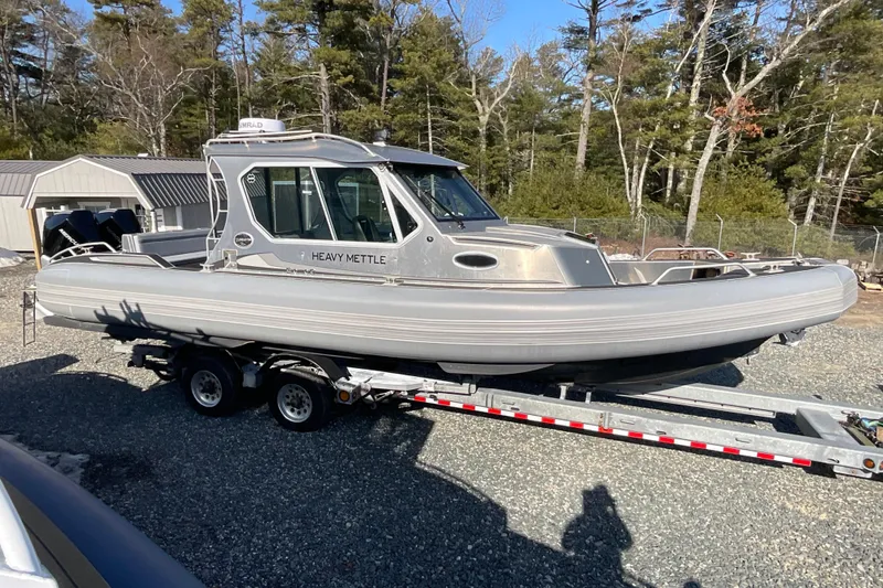 Slide: The Image of 2025 Life Proof 31 GT Coupe boat on trailer, surrounded by trees and sheds. - 3