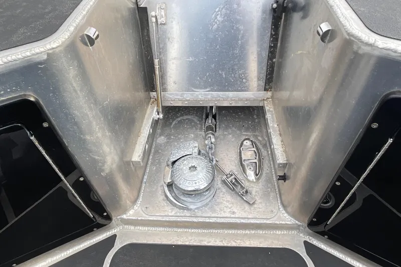 Slide: The Image of Anchor compartment of 2025 Life Proof 31 GT Coupe boat, featuring metal fittings and chain. - 33