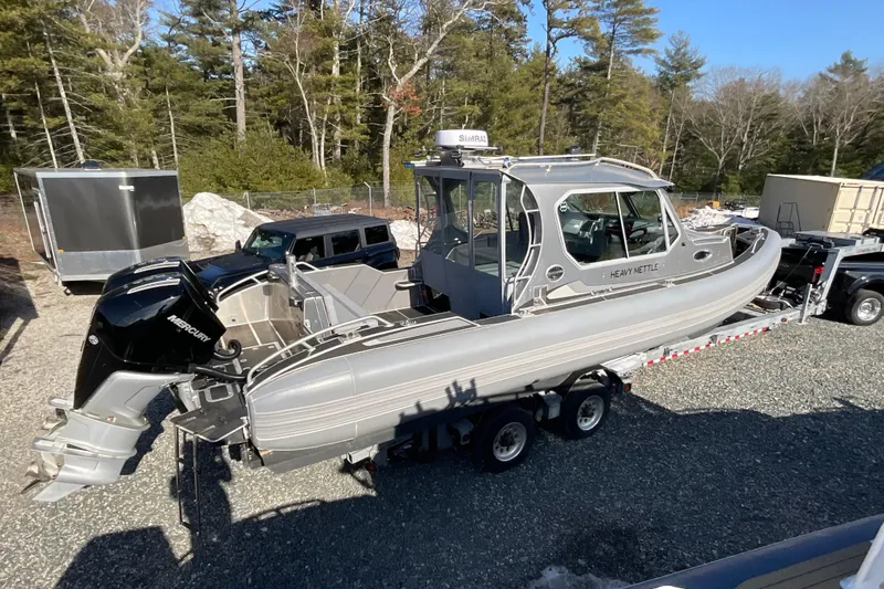 Slide: The Image of 2025 Life Proof 31 GT Coupe boat on trailer, parked outdoors, surrounded by trees. - 5