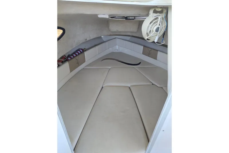 Slide: The Image of 2004 Seaswirl Striper 2101 Walkaround O/B cabin interior with cushioned seating and fan. - 10