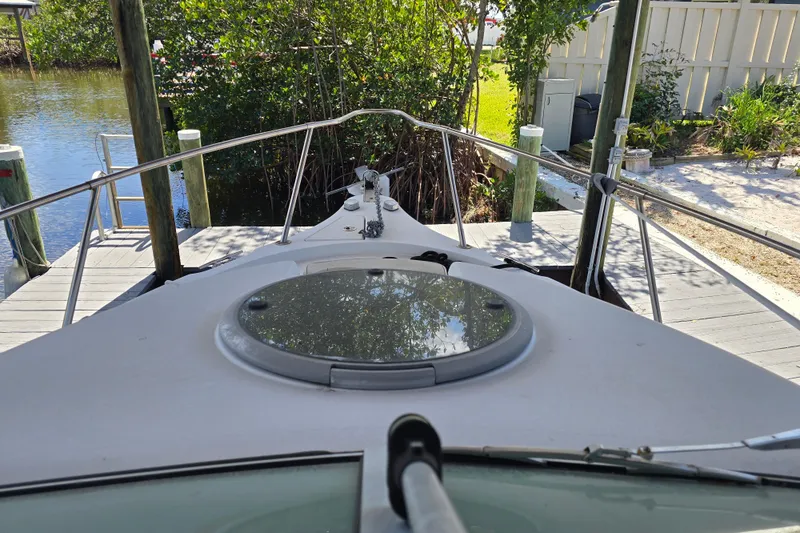 Slide: The Image of 2004 Seaswirl Striper 2101 Walkaround O/B docked, view from bow with lush greenery. - 11