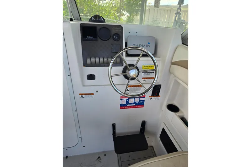 Slide: The Image of 2004 Seaswirl Striper 2101 Walkaround O/B helm with steering wheel and Garmin device. - 13