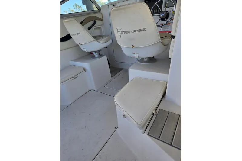Slide: The Image of 2004 Seaswirl Striper 2101 Walkaround O/B interior with white seating and steering wheel. - 18