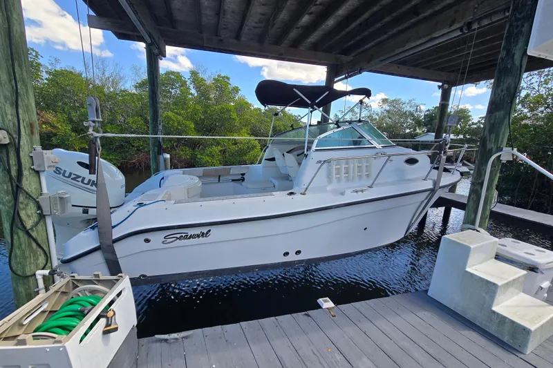 Slide: The Image of 2004 Seaswirl Striper 2101 Walkaround O/B boat docked under a wooden canopy. - 3