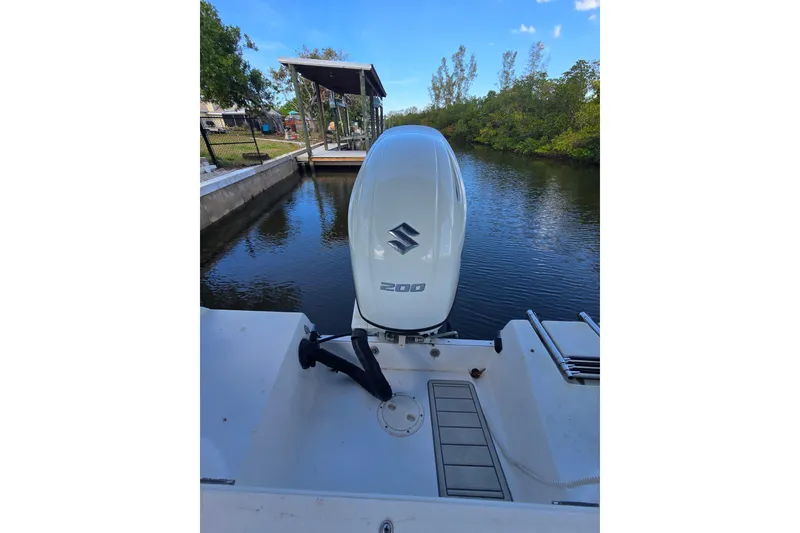 Slide: The Image of 2004 Seaswirl Striper 2101 Walkaround O/B with Suzuki outboard engine by a dock. - 4