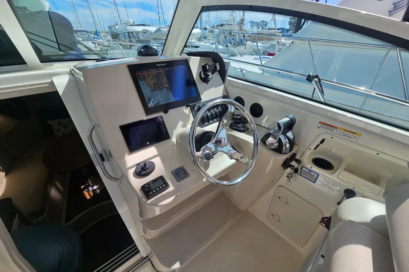 Slide: The Image of 2018 Boston Whaler 315 Conquest helm with navigation screens and steering wheel. - 10