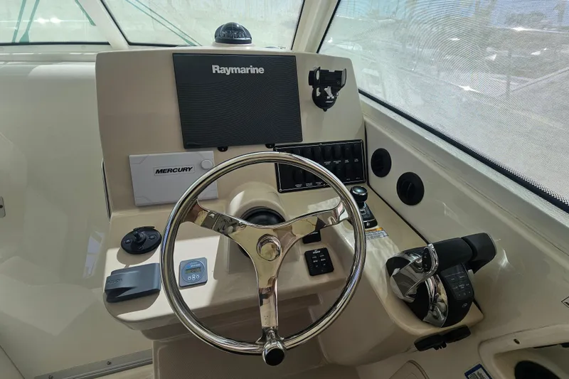 Slide: The Image of Helm of 2018 Boston Whaler 315 Conquest with Raymarine electronics and Mercury controls. - 11