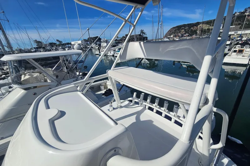 Slide: The Image of 2018 Boston Whaler 315 Conquest boat docked in a marina, featuring upper deck seating. - 18