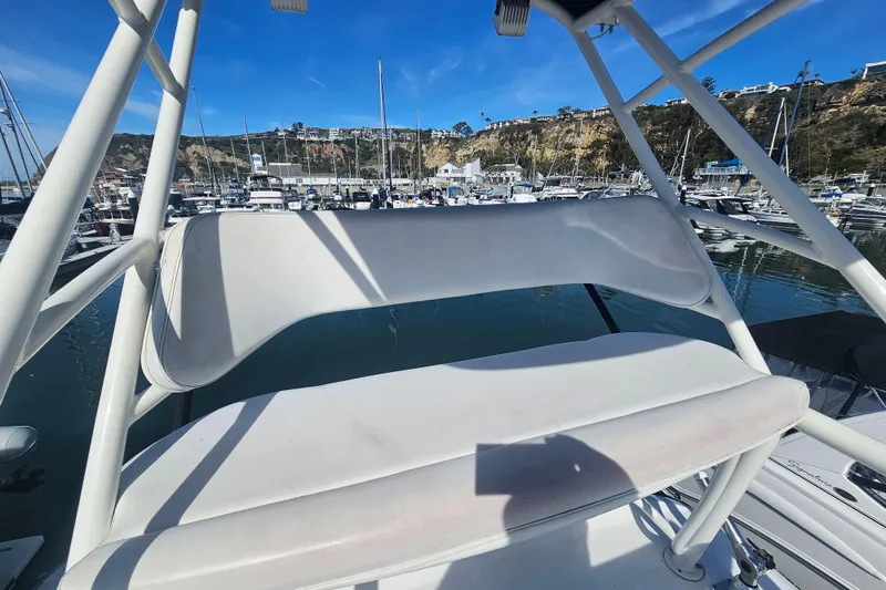 Slide: The Image of 2018 Boston Whaler 315 Conquest boat seating area in a marina setting. - 19