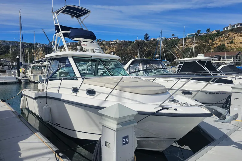 Slide: The Image of 2018 Boston Whaler 315 Conquest docked at marina, surrounded by other boats. - 2