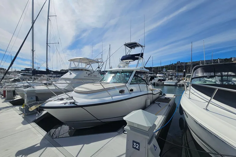 Slide: The Image of 2018 Boston Whaler 315 Conquest docked at marina under blue sky. - 3