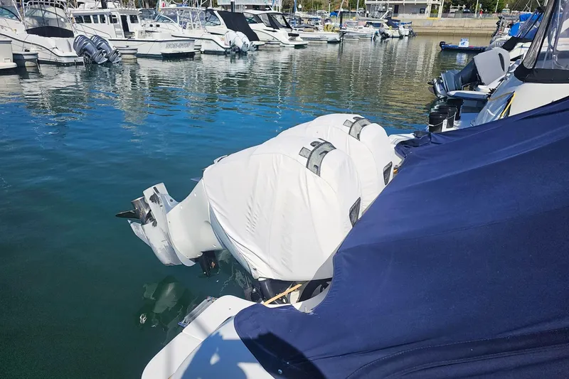 Slide: The Image of 2018 Boston Whaler 315 Conquest docked with covered engines in a marina. - 4