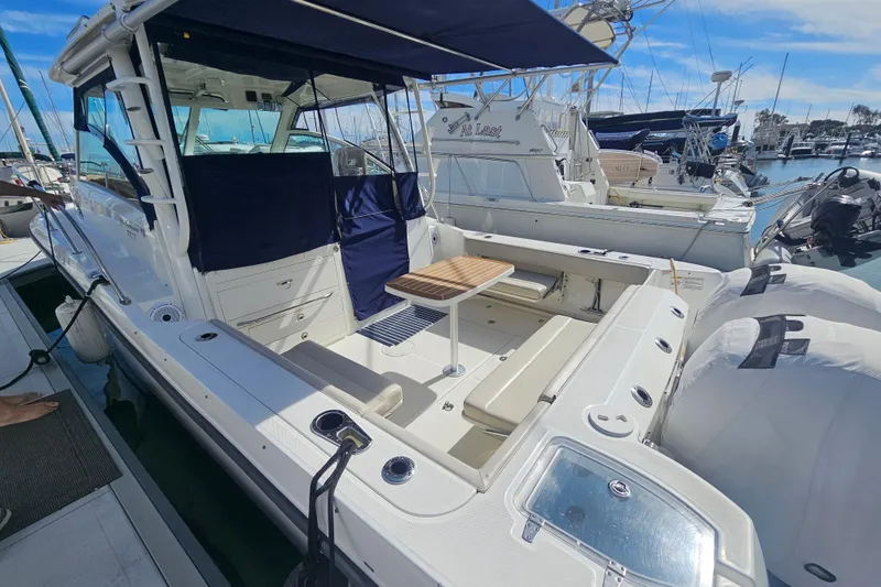 Slide: The Image of 2018 Boston Whaler 315 Conquest docked, featuring spacious deck and seating area. - 8