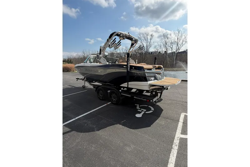 Slide: The Image of 2019 MasterCraft XT20 boat on trailer in parking lot, sunny day. - 11