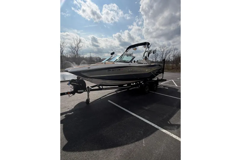 Slide: The Image of 2019 MasterCraft XT20 boat on trailer in parking lot under cloudy sky. - 12