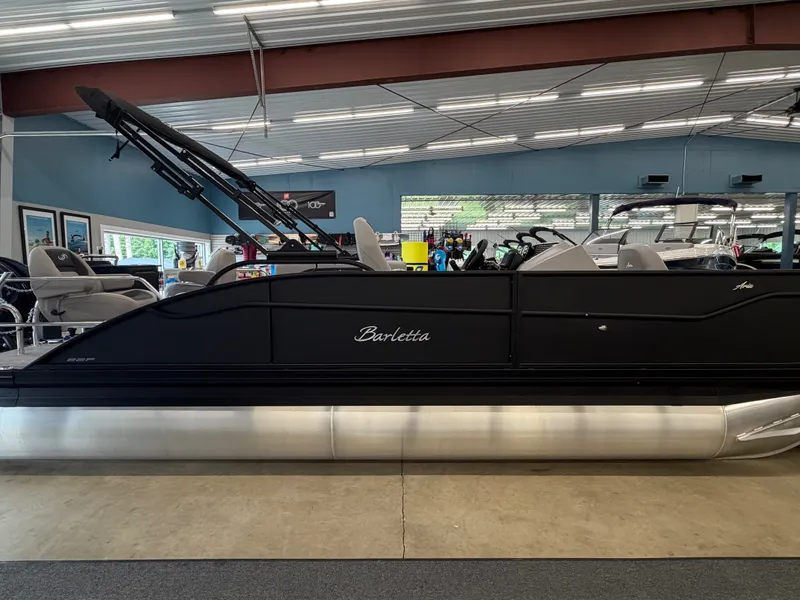 Slide: The Image of The image shows a Barletta A22F pontoon boat in a showroom. - 1