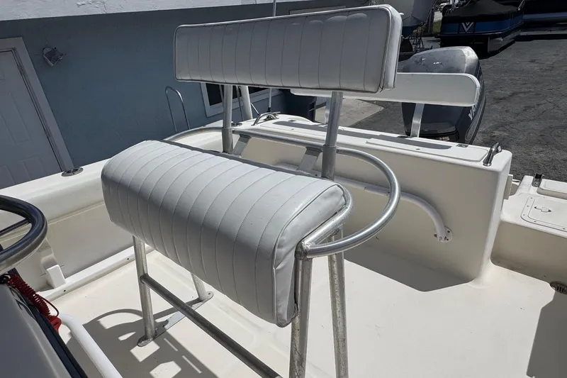 Slide: The Image of 1998 Legacy Boat 220 Sea Era with white cushioned seating and metal frame. - 13