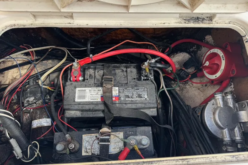 Slide: The Image of Battery compartment of a 1998 Legacy Boat 220 Sea Era with wiring and switch. - 26