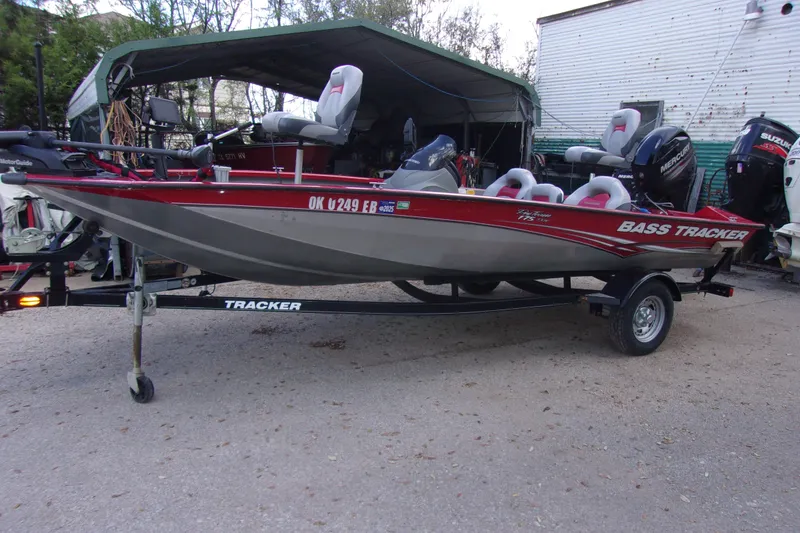 The Image of 2012 Tracker Pro Team 175 TXW bass boat on trailer, parked outdoors. - 1