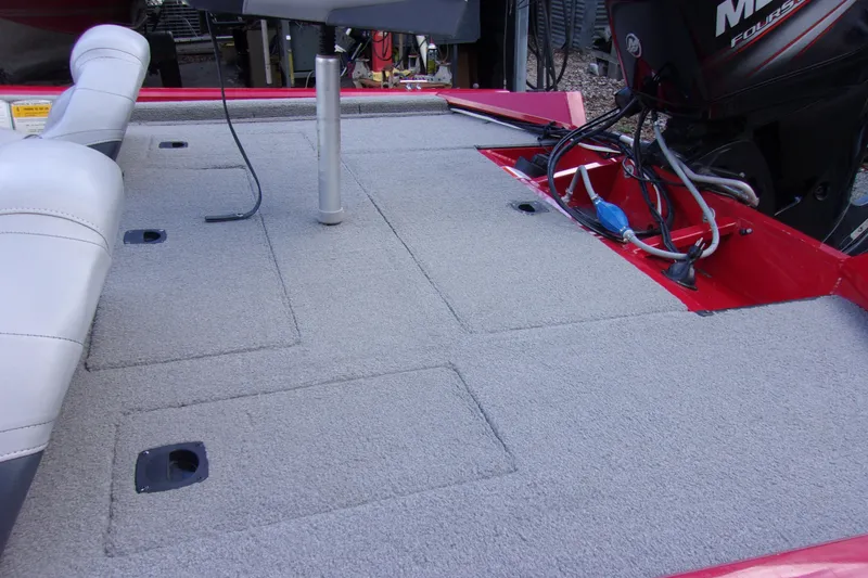 Slide: The Image of 2012 Tracker Pro Team 175 TXW boat interior with carpeted deck and motor. - 8