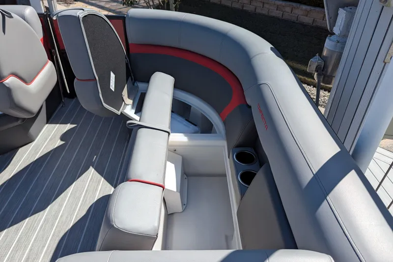 Slide: The Image of 2023 Trifecta 20CC 2.75 boat interior with gray and red seating, cup holders, and storage. - 11
