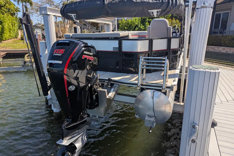 Slide: The Image of 2023 Trifecta 20CC 2.75 pontoon boat with Mercury 115 Pro XS engine on dock. - 17
