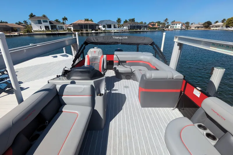 Slide: The Image of 2023 Trifecta 20CC 2.75 pontoon boat docked, featuring spacious seating and modern design. - 7