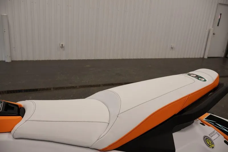Slide: The Image of 2026 Yamaha WaveRunner JetBlaster LTD seat, white and orange design, in a showroom. - 29