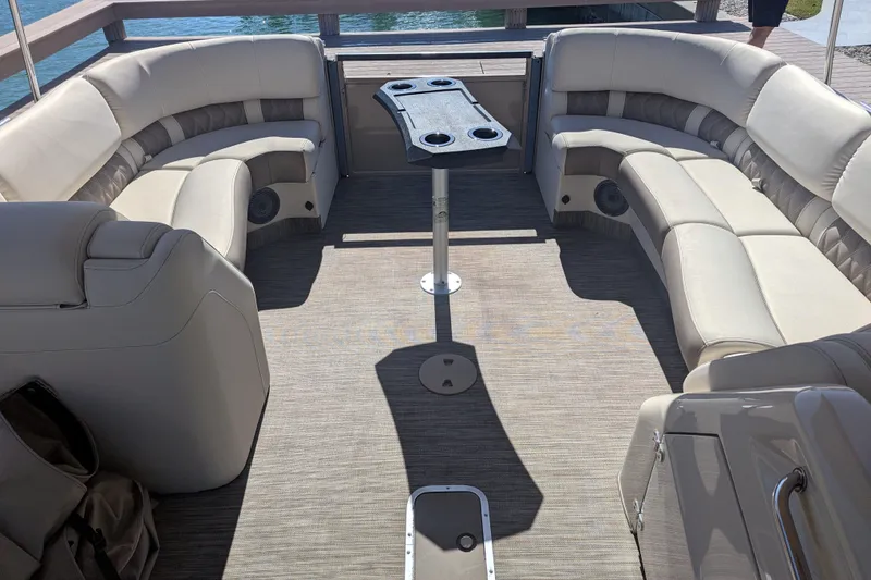 Slide: The Image of 2022 Bennington QXFBAX2 boat interior with beige seating and central table. - 11