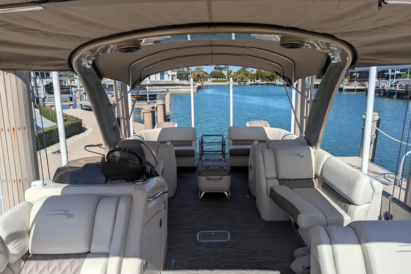 Slide: The Image of Luxurious 2022 Bennington QXFBAX2 pontoon boat interior with plush seating and waterfront view. - 13