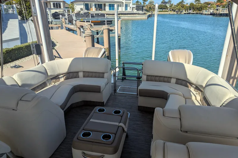 Slide: The Image of Luxurious 2022 Bennington QXFBAX2 pontoon boat interior with plush seating and scenic waterfront view. - 15