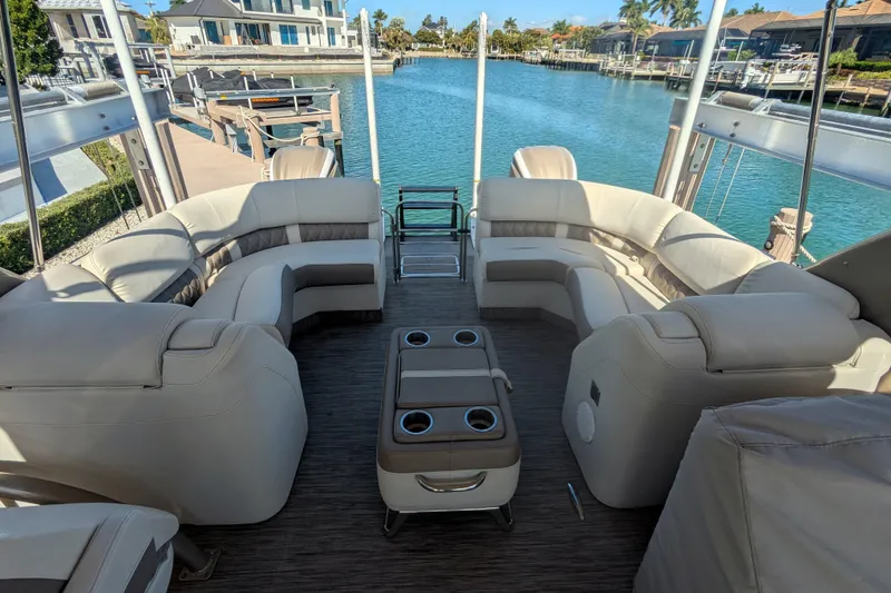 Slide: The Image of Luxurious 2022 Bennington QXFBAX2 pontoon boat interior with plush seating and scenic waterfront view. - 18