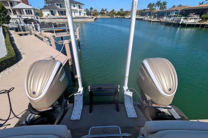 Slide: The Image of 2022 Bennington QXFBAX2 boat with dual Yamaha engines docked by waterfront homes. - 19