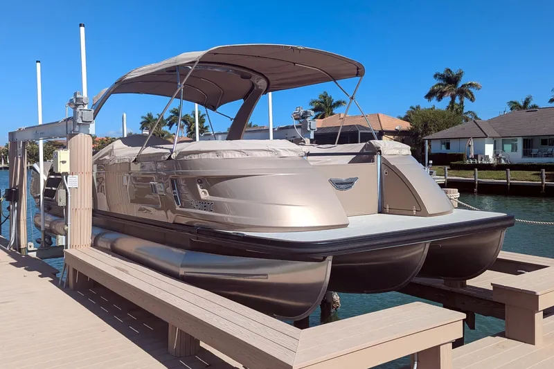 Slide: The Image of 2022 Bennington QXFBAX2 pontoon boat docked by waterfront homes. - 21