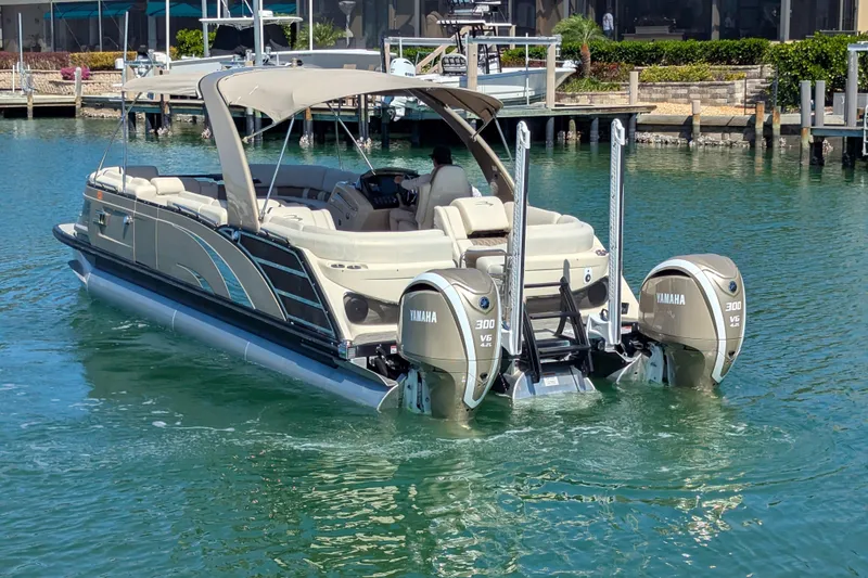 Slide: The Image of 2022 Bennington QXFBAX2 pontoon boat with dual Yamaha 300 V6 engines on water. - 22