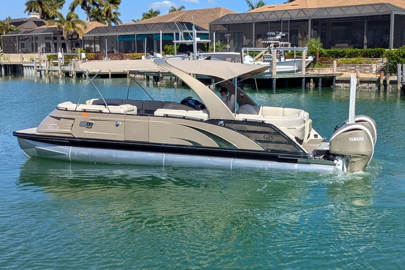 Slide: The Image of 2022 Bennington QXFBAX2 pontoon boat on water, featuring Yamaha engine, near waterfront homes. - 3