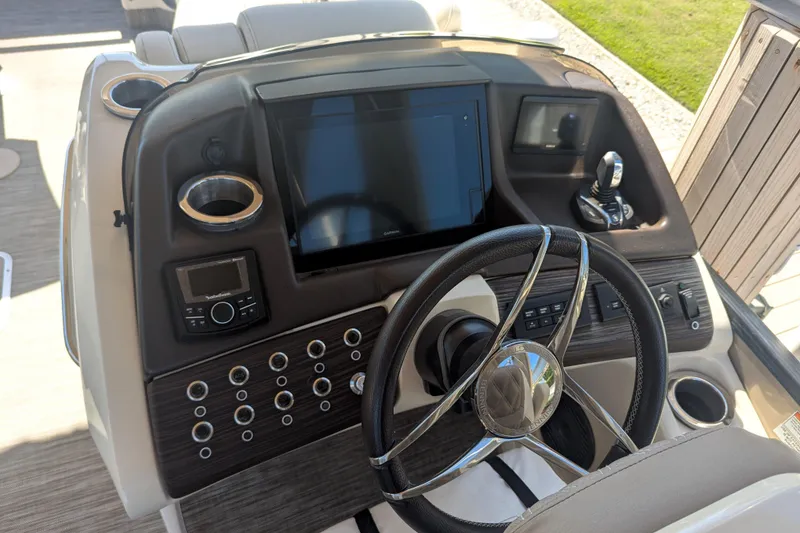 Slide: The Image of 2022 Bennington QXFBAX2 boat dashboard with steering wheel and control panel. - 4