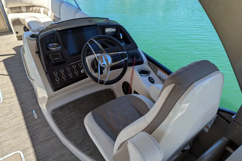 Slide: The Image of 2022 Bennington QXFBAX2 boat helm with steering wheel and control panel on water. - 5