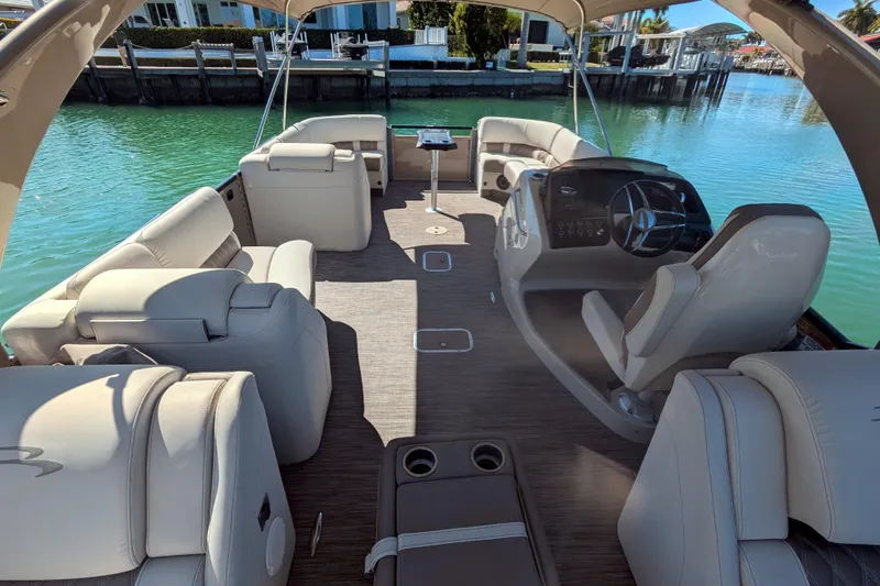 Slide: The Image of Interior of a 2022 Bennington QXFBAX2 pontoon boat with luxurious seating and steering console. - 7