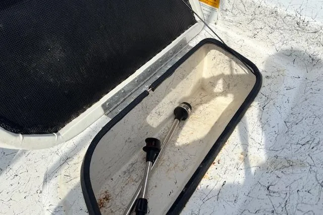 Slide: The Image of Open storage compartment on 2009 Kenner 19VX boat with metal rods inside. - 15