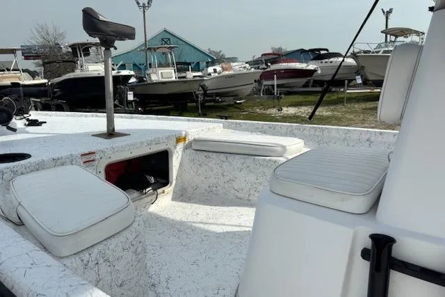 Slide: The Image of 2009 Kenner 19VX boat interior with white seating, docked among other boats. - 22