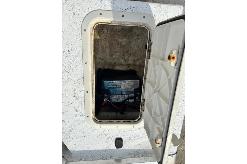 Slide: The Image of Battery compartment of a 2009 Kenner 19VX boat with open hatch. - 34