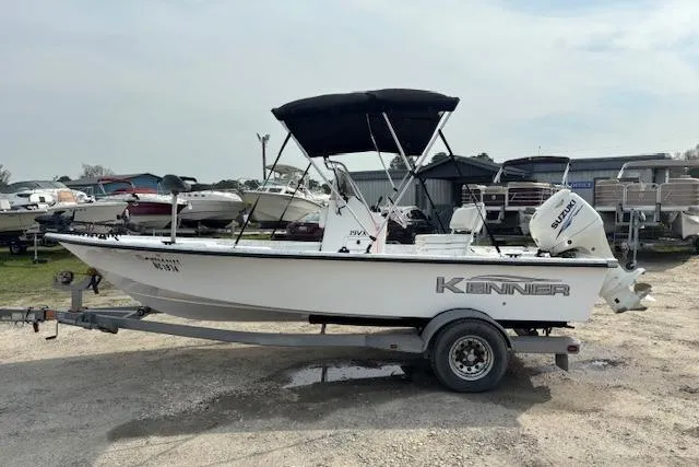 Slide: The Image of 2009 Kenner 19VX boat with Suzuki outboard motor on trailer, parked outdoors. - 7