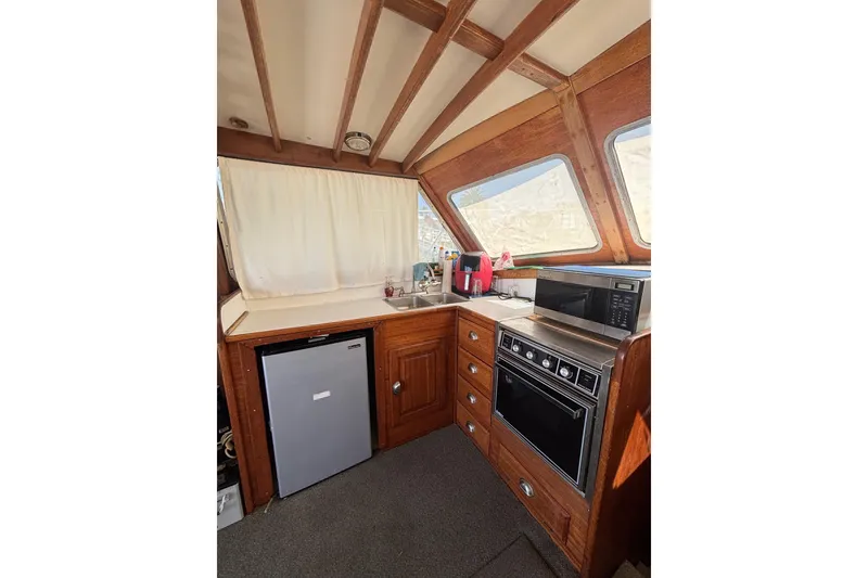 Slide: The Image of 1973 Luhrs 290 Sport Fisherman interior kitchen with appliances and wooden cabinetry. - 6
