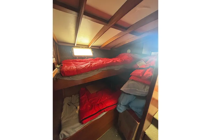 Slide: The Image of 1973 Luhrs 290 Sport Fisherman cabin with bunk beds and red bedding. - 8