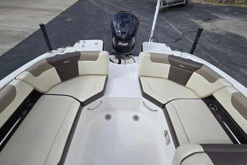 Slide: The Image of 2019 Chaparral 230 Suncoast boat interior with seating and outboard motor. - 14